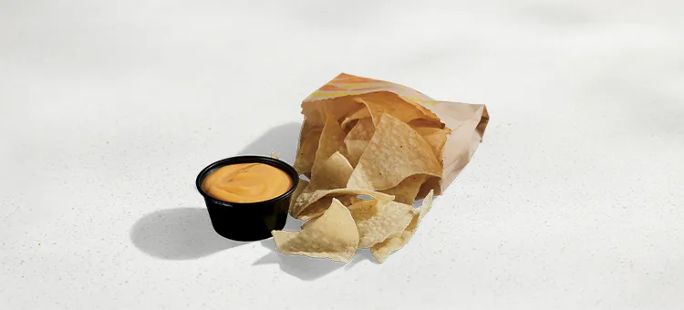 Chips and Nacho Cheese Sauce: Warm-and-crispy tortilla chips with a side of warm nacho cheese sauce for dipping.
