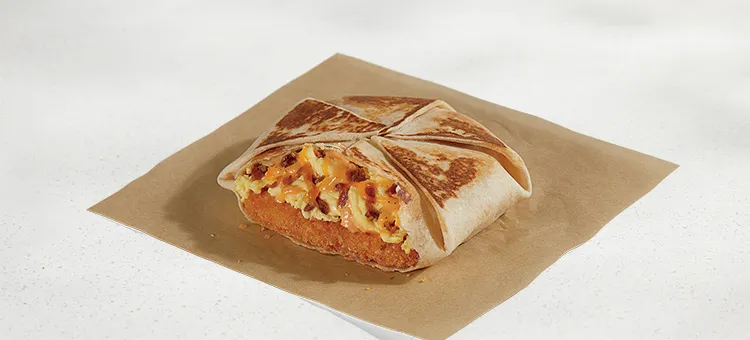 Breakfast Crunchwrap Bacon: A warm flour tortilla filled with a hash brown, fluffy cage-free eggs, flavorful bacon, Creamy…