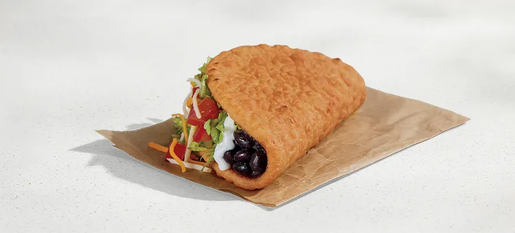 Black Bean Chalupa Supreme: A warm-and-flaky flatbread shell filled with slow-simmered black beans, lettuce, diced…