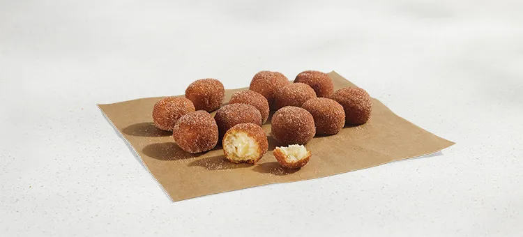 Cinnabon Delights® 12 Pack: A dozen warm donut holes dusted in cinnamon sugar and filled with Cinnabon® cream-cheese…